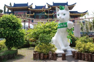 A giant cat statue - sporting a green ribbon to celebrate the end of Ramadan - guards the entrance to Kuching's Chinatown. Photo / Jim Eagles