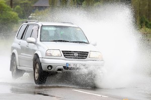 A car drives through flood waters in Pitt Town near Richmond, Australia. Photo / Getty Images