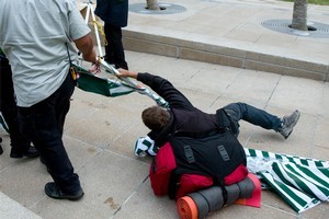 A protestor holds his ground as security staff remove Occupy Auckland from Aotea Square. Photo / Dean Purcell