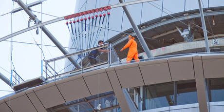 A man is spoken to by police on the 54th floor of Auckland's Sky Tower. Photo / Michael Craig