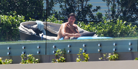 A sunbather enjoys the pool at the home of failed financier Mark Hotchin. Photo / Doug Sherring