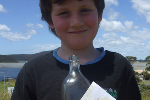 Shayde Flood with the bottle that washed up on 90 Mile Beach. Photo / Supplied