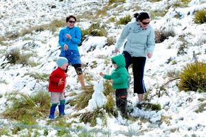 People dodging snowballs on the Crown Range yesterday. Photo / Linda Robertson