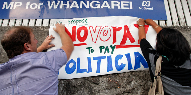 Primary school teachers fix signs to the wall outside Whangarei MP Phil Heatley's office during this morning's nationwide protest. Photo / John Stone