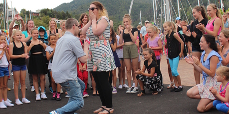 Andrew Bewley gets down on one knee to propose to partner Jenny Sanders at Whangarei Town Basin, surrounded by a dancing flash mob. Photo / Supplied