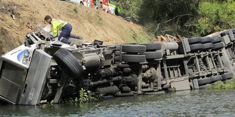 A fireman attempts to remove the driver's belongings from the cab.