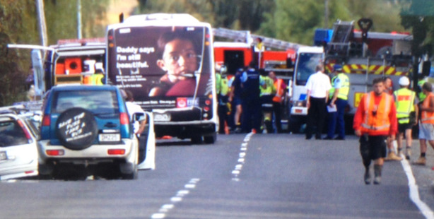 Emergency services attend the scene of a serious crash between a car and a van on State Highway 16 today. Photo / Sarah Ivey