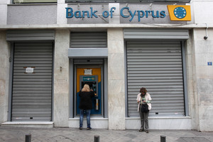 Customers of Bank of Cyprus use the ATM in central Athens. Photo / AP