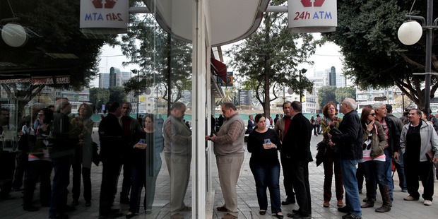 People queue at an ATM outside a closed Laiki Bank branch in capital Nicosia, Cyprus. Photo / AP