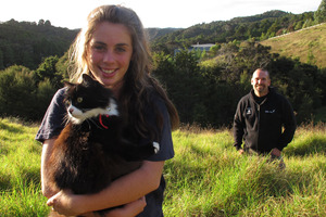 Sixteen-year-old Phoenix Bright-Young with Lucky the cat and Bay Bush Action trustee Craig Salmon with the Opua State Forest in the distance. Photo / APN