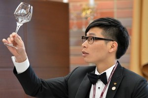 Taiwanese contestant Thomas Ho checks a glass before serving wine to judges during the quarter-final of the 14th world sommelier contest in Tokyo.Photo / AFP