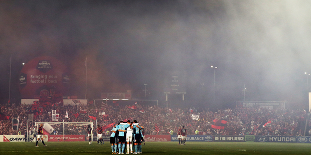 A flare is lit in the crowd during the round 26 six A-League match between the Western Sydney Wanderers and Sydney FC. Photo / Getty Images