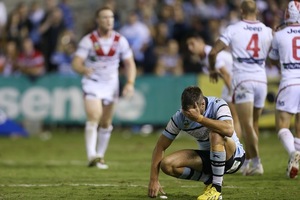 Beau Ryan of the Sharks looks dejected as Dragons players celebrate victory. Photo / Getty Images