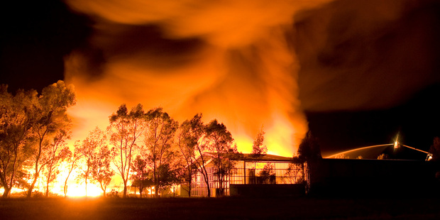 A fire crane (bottom right) is dwarfed by a cool store fire at Tamahere, south of Hamilton. Photo / James Madelin