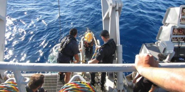 A Navy diver enters the water off the Kawhia coast. Photo / CAA