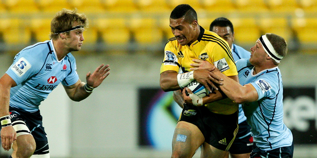 Ardie Savea of the Hurricanes is tackled by Michael Hooper (R) and Pat McCutcheon of the Waratahs during the round eight Super Rugby match between the Hurricanes and the Waratahs Photo / Getty Images.
