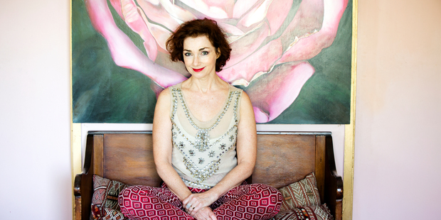 Stylist and makeup artist Margaret Petchell in her home in front of one of her paintings. Photo / Babiche Martens