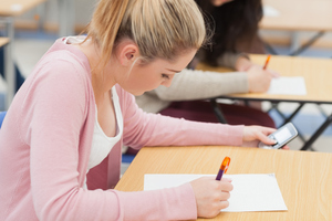 Students have been caught using cellphones in exams, sneaking in notes, communicating with other students and even organising stand-ins. Photo / Getty Images