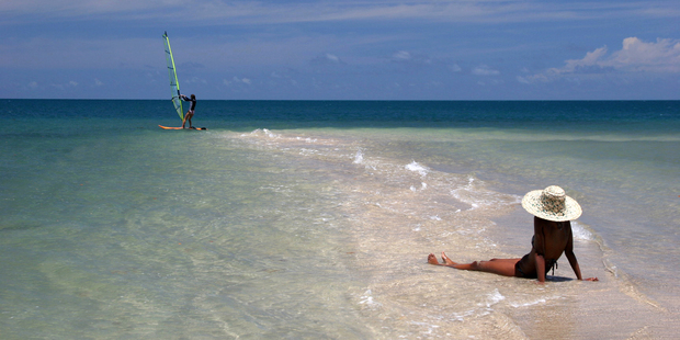 Sunbathing and windsurfing at Volivoli Beach Resort, Fiji. Photo / Supplied