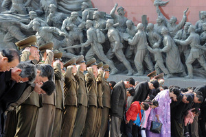 Military personnel salute as civilians bow to giant statues of the late North Korean leaders, Kim Il Sung and his son Kim Jong Il. Photo /AP