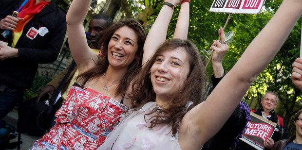 Pro-gay marriage activists celebrate with champagne after French lawmakers legalised same-sex marriage. Photo / AP