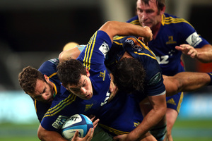 John Hardie of the Highlanders is tackled by Nic White of the Brumbies. Photo / Getty Images