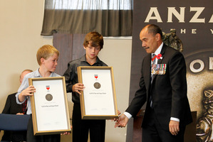 Governor-General Sir Jerry Mateparae presents Will White (left) and Sergio Schuler with their Anzac of the Year Awards in Waihi yesterday. Photo / Christine Cornege