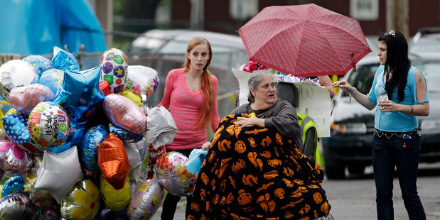 Deborah Knight, center, grandmother of Michelle Knight, drives her wheelchair past the home of Gina DeJesus in Cleveland. Photo / AP