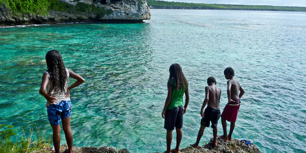Local children jump from rocks into the ocean on the Island of Lifou in the Loyalty Islands, New Caledonia. Photo / Supplied