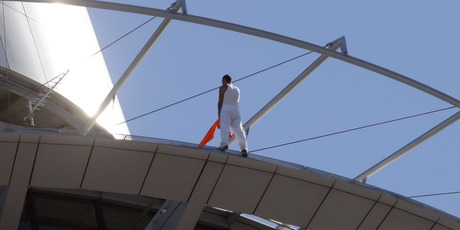 The man uses his jacket to balance on the side of the Sky Tower rim. Photo / Doug Sherring