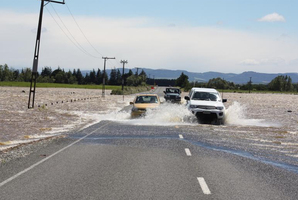 Vehicles negotiate flooding south of Hedgehope, where the Titipua and College Streams overflowed yesterday. Photo / Allison Rudd