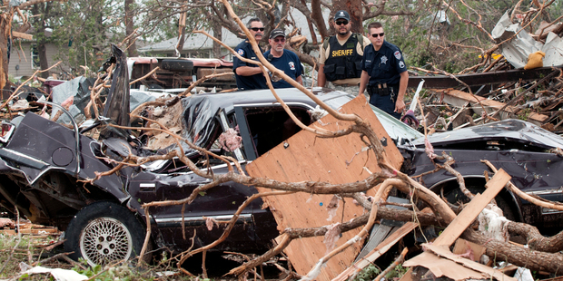 Emergency personnel look through debris on near Granbury, Texas after ten tornadoes touched down in several small communities in Texas, leaving at least six people dead. Photo / AP