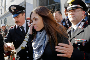 Karima el-Mahroug's is escorted outside the Milan's Law court after giving her testimony at the trial of three former Berlusconi aides accused with procuring her.Photo / AP