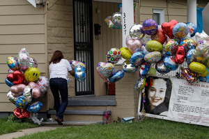 Culema Nevarez adds balloons to a growing tribute outside the house of Gina DeJesus. Photo / AP