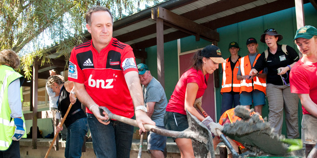 Prime Minister John Key helps out the Farmy Army volunteers, at Linwood College, following the 6.3 magnitude earthquake in March 2011. Photo / File