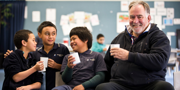 Milo Kids Hamiora Samuels (9), Sonny Pawa (11) and Heperone Kiao (11) enjoy a break with Steve Farrelly before starting the morning at Randwick Park School in Manurewa. Photo / Greg Bowker
