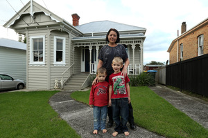 Laurene Dearlove with sons Mason, 2 and Riley, 4, in front of their home which has been moved from Western Springs to Morningside. Photo / Getty Images