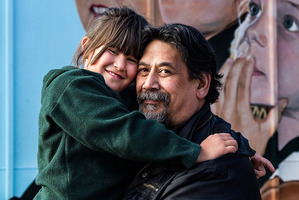 Andrew Smith with his daughter Serenity in front of a mural of her at the school yesterday. Photo / Martin Hunter