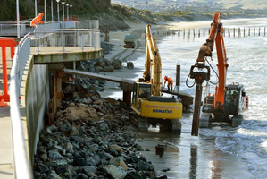 Contractors take advantage of low tide yesterday to continue piling rocks against the bottom of the St Clair sea wall. Photo / Stephen Jaquiery