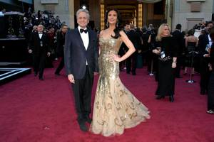 Michael Douglas, pictured with wife Catherine Zeta-Jones at this year's Oscars, is confident he has beaten throat cancer. Photo / AP