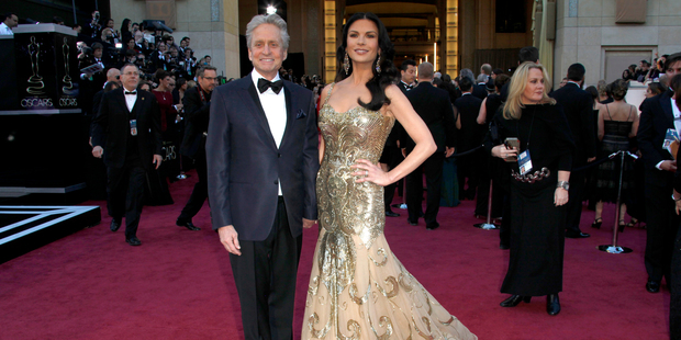 Michael Douglas, pictured with wife Catherine Zeta-Jones at this year's Oscars, is confident he has beaten throat cancer. Photo / AP