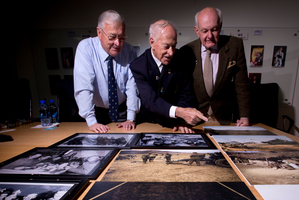War veterans Jim Newman (left), Wally Wyatt and David Mannering look over some of the photographs. Photo / Dean Purcell
