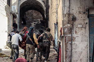 A group of Free Syrian Army fighters carry a wounded comrade in the town of Harem, Syria. Photo / AP