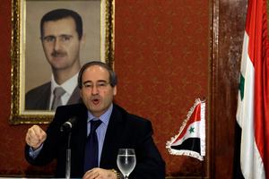 Backdropped by a framed picture of Syrian President Bashar al-Assad, is Syria's Deputy Foreign Minister Faisal al-Mokdad. Photo / AP