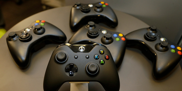 The new controller for Microsoft's next-generation Xbox One entertainment and gaming console system is shown with older-generation controllers behind it. Photo / AP