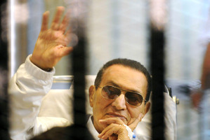 Hosni Mubarak waves to his supporters from behind bars. Photo /AP