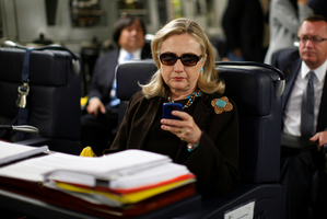 This file photo of then-Secretary of State Hillary Rodham Clinton working from a desk inside a C-17 military plane is now being used as her Twitter profile photo. Photo / AP