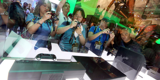 E3 2013 attendees interact with Xbox One at Microsoft's booth at E3 2013 in Los Angeles. Photo / AP