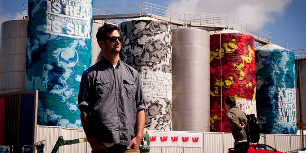 Graffiti artist Askew One, aka Elliot O'Donnell, with his latest work done on the tanks at Wynyard Quarter. Photo / Dean Purcell