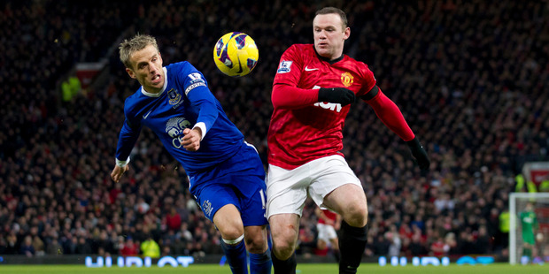 Manchester United's Wayne Rooney (right) fights for the ball against Everton's Phil Neville. Photo / AP